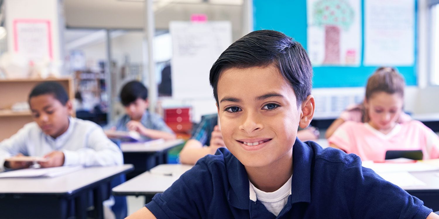 Smiling child in a classroom.